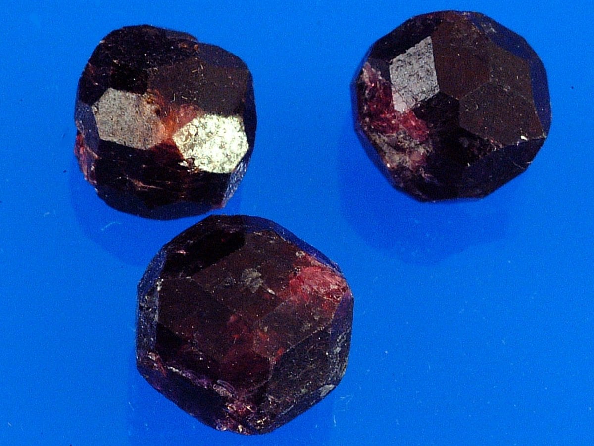 Trois cristaux d'almandin rouge sombre aux faces de dodécaèdre